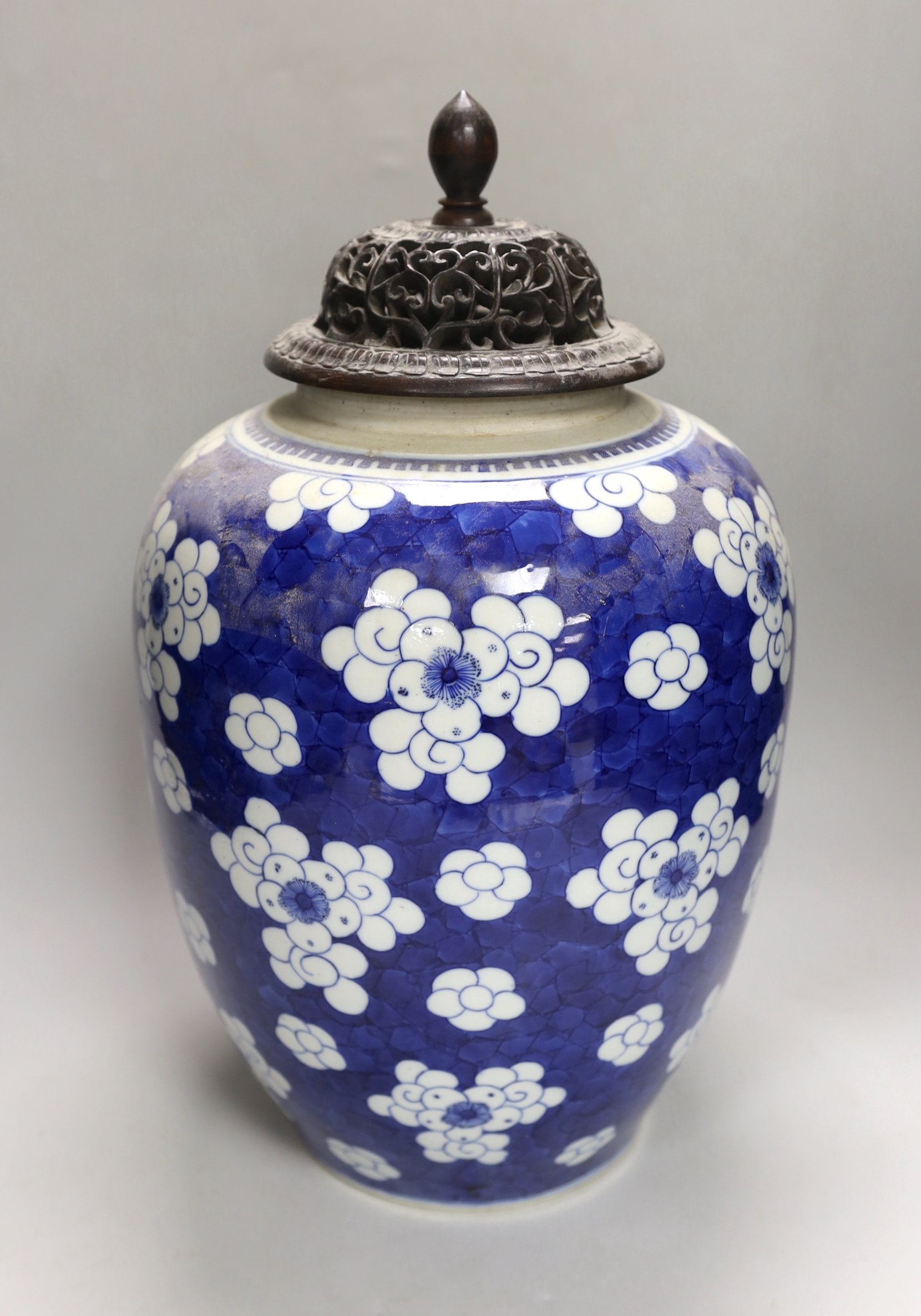 A large Chinese blue and white prunus pattern vase, with carved hardwood cover, 42cm (a.f.)